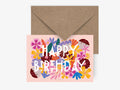 Colorful 'Happy Birthday' card with floral designs on a pink background, featuring a brown envelope.